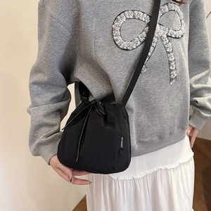 Black drawstring bucket bag made of nylon fabric for casual crossbody and shoulder use