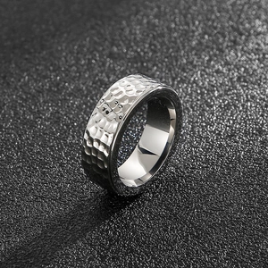 Close-up of a silver men's titanium steel ring with hammered texture and polished finish