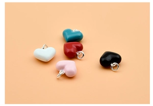 Detailed view of colorful 925 sterling silver heart charms in blue, red, white, pink and black