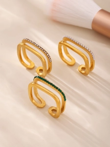 Detailed shot of a 3-piece gold ring set with zircon, pearls, and green gemstones