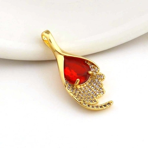 Macro detail of red drop-shaped gemstone pendant with micro-set zircon in gold finish