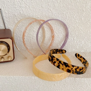 Collection of acetate headbands in solid colors and leopard print on a white tabletop