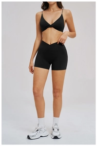 Macro detail of high-elastic black yoga set featuring twisted bra and cross-waist shorts