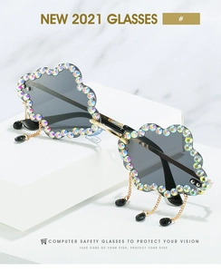 Close-up of cloud-shaped sunglasses with gradient lenses, rhinestones and rain pendants