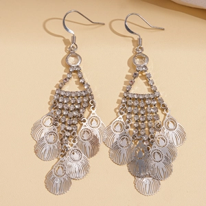 Silver hollow leaf tassel drop earrings with sparkling white crystals on beige background
