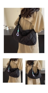 Detail of black quilted shoulder bag featuring large capacity and colorful pendant charm