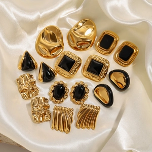 Vintage gold and black stainless steel earrings set on white silk background