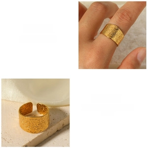 Macro detail of wide C-shaped gold stainless steel ring with a hammered textured finish