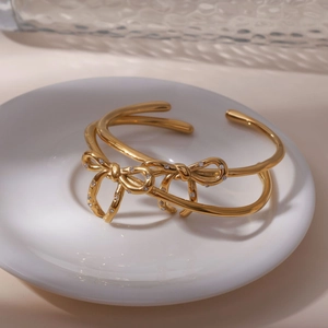 Vue macro du bracelet jonc nœud en or 18K avec zircons posé sur une coupelle