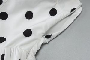 Detailed macro view of invisible side zipper on a white polka dot summer dress