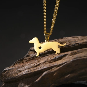 Golden dachshund pendant necklace with heart cutout on dark wood background