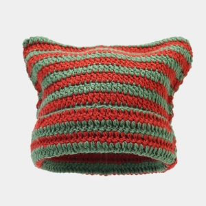 Close-up of red and green striped knit hat texture with handmade cat ear details