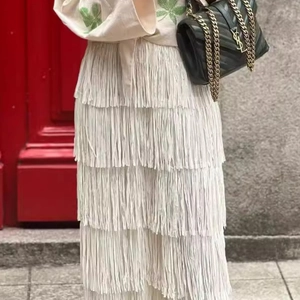 Streetstyle-Ansicht eines weißen Stufenrocks mit Fransen und eleganten Tassel-Details