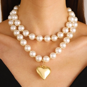 Elegant layered white pearl necklace with a polished gold heart pendant for women