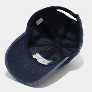 Detail view of cotton inner band, stitching and wash label on navy blue baseball cap