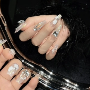 Handmade long coffin press-on nails with pink base, white floral motifs, and silver rhinestones