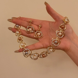 Detalle de conjunto de joyería dorada con perlas de colores y cristales brillantes