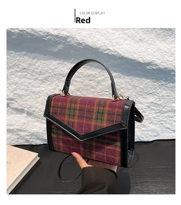 Detail des roten Karomusters und des V-förmigen Lederdeckels an einer kleinen Handtasche