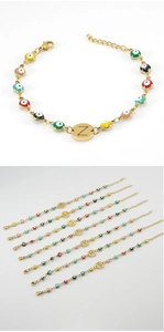 Detail of evil eye bracelets with personalized initial charms and gold lobster clasp