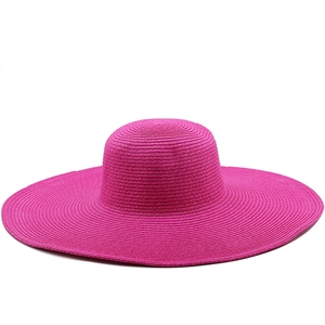 Detail of fuchsia straw sun hat showing wide brim texture and fine spiral weave pattern