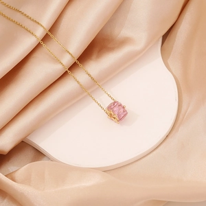 Elegant gold necklace with pink square gemstone pendant and a delicate bow tie charm