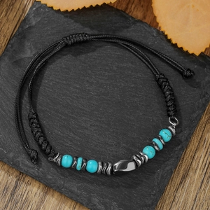 Adjustable men's woven bracelet with turquoise beads and hematite on a black slate base