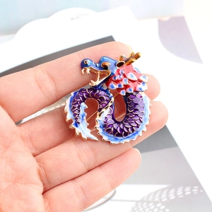 Macro view of Chinese zodiac dragon king brooch with enamel details and gold plating