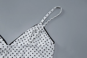 Detail of adjustable black strap with metal buckle and black lace trim on polka dot top
