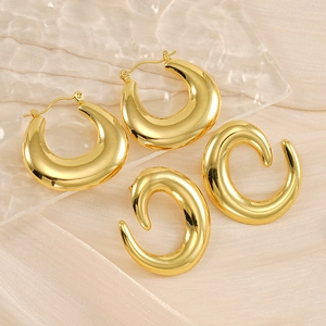 French style hollow geometric gold earrings and irregular C-shaped studs on silk tray