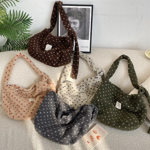 Detail view of plush heart-pattern tote bags in five colors with a soft winter aesthetic