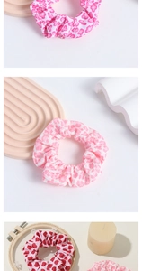 Close-up of pink scrunchies with floral, leopard and heart patterns on stone displays