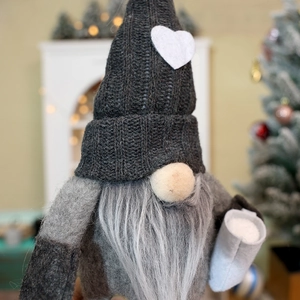 Close-up of a Christmas gnome with grey knitted heart hat and long beard detail