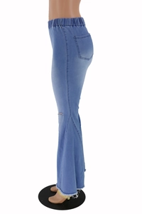 Detail view of high-waisted light blue flare jeans with knee distressing and frayed hems