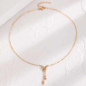 Close-up of golden butterfly pendant necklace with zircon inlay and tassel chains