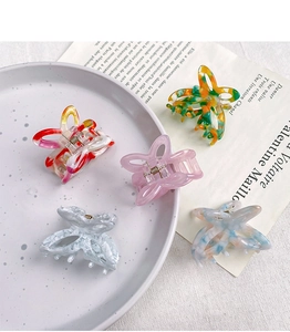 Detail view of acetate butterfly hair claws with marble textures and metal spring in five colors