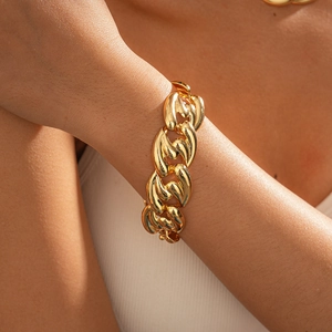 Close-up of a chunky gold chain link necklace with a polished metallic finish on a model