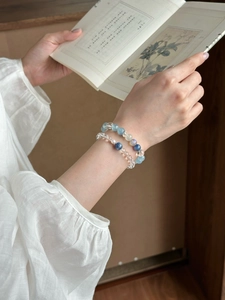 Detailansicht von Armbändern aus weißem Kristall und blauen Perlen beim Lesen