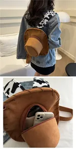 Detailed view of cowboy hat backpack with cow print straps holding a smartphone