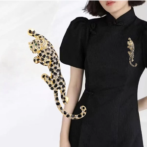 Sparkling leopard brooch with black and gold rhinestones pinned on a black garment