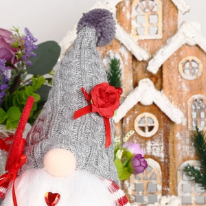 Gnome de Noël tricoté avec bonnet à rose rouge et barbe douce sur fond de bois rustique
