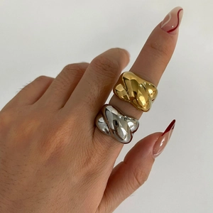 Thick minimalist twisted cross rings in gold and silver finish on hand