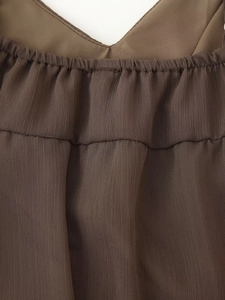 Detail of V-neckline with pleated design on brown bohemian chiffon summer dress