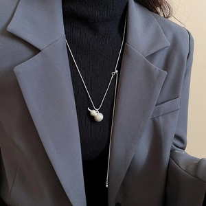 Dettaglio del ciondolo a forma di zucca in argento opaco su collana a Y regolabile