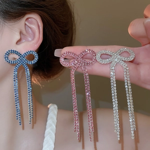 Detailed view of rhinestone bow tassel earrings in blue, pink and silver color options