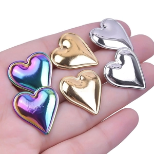 Detailed view of heart-shaped stainless steel earrings in gold, silver, and rainbow colors