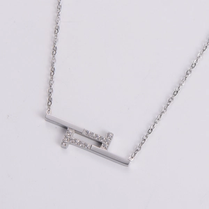 Detail of silver geometric pendant with micro-pave crystals on a minimalist chain necklace