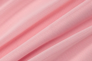 Macro shot of pink mesh tulle fabric showing delicate texture and layered pleats