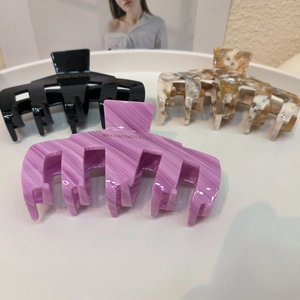 Vue détaillée des pinces à cheveux en acétate noires, violettes et marbrées brunes