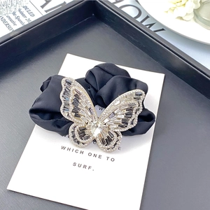 Elegant black fabric scrunchie featuring a large sparkling crystal butterfly ornament