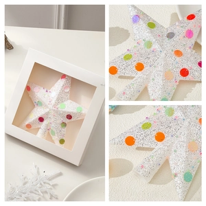 White glitter star tree topper with colorful sequins in a premium 3-grid display